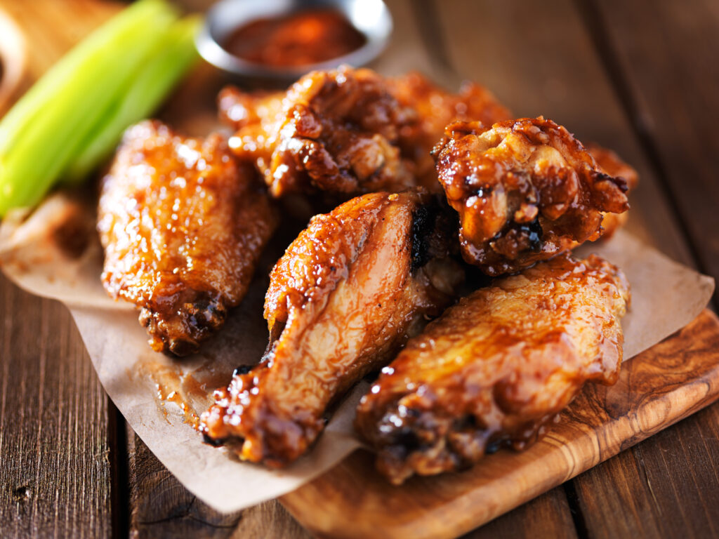 barbecue chicken wings close up on wooden tray